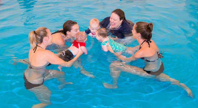 our moms and babies taking a baby swim class