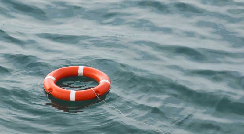 A life preserver with a rope tied to it floating in the water