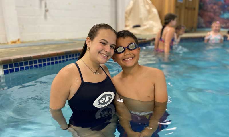 Njswim teacher and swim student smiling in the pool