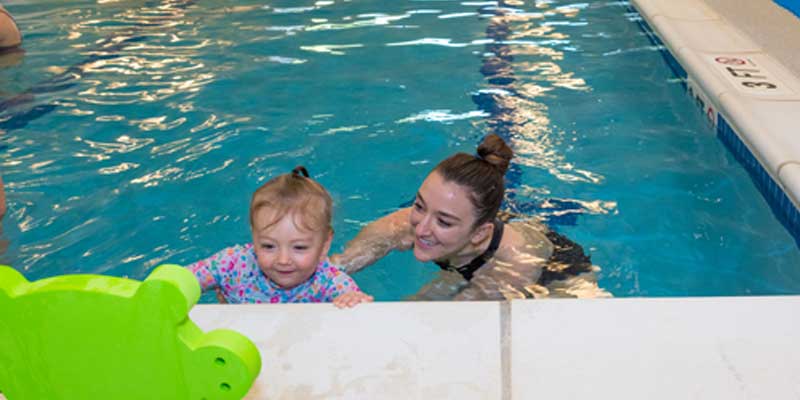 Swim teacher with baby girl in the pool at Njswim Turnersville