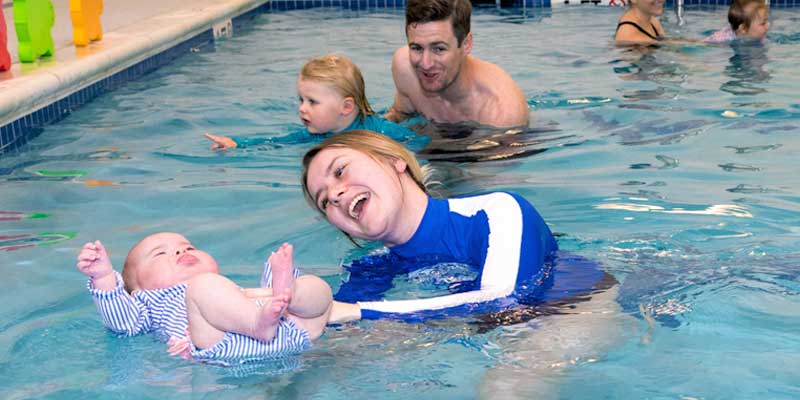 Young children with their parent learning to float with Njswim teacher in a Water Babies SwiClass
