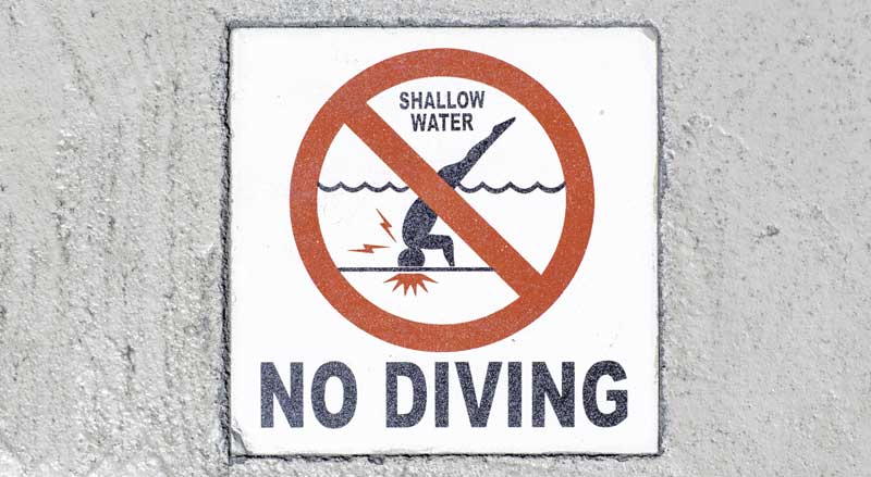 A sign warning swimmers that no diving is allowed due to shallow water