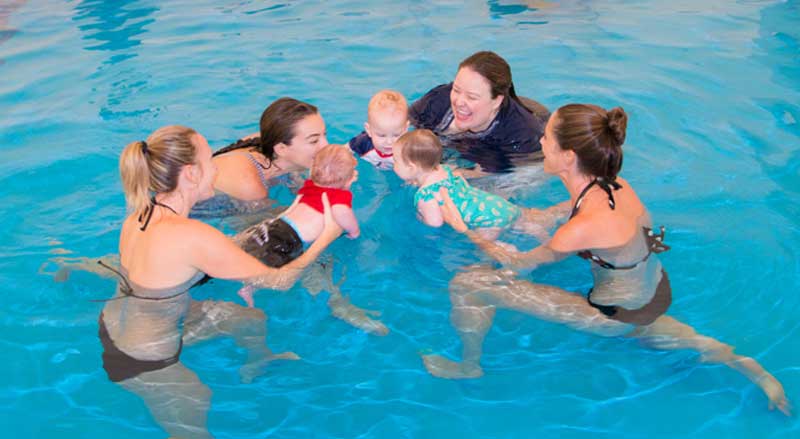 Adults and infants in a New Jersey Swim Schools Water Babies class.
